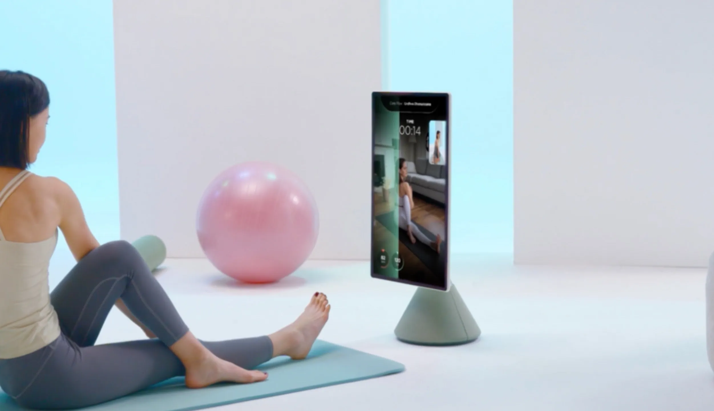 Woman doing yoga next to the OLED Glow display